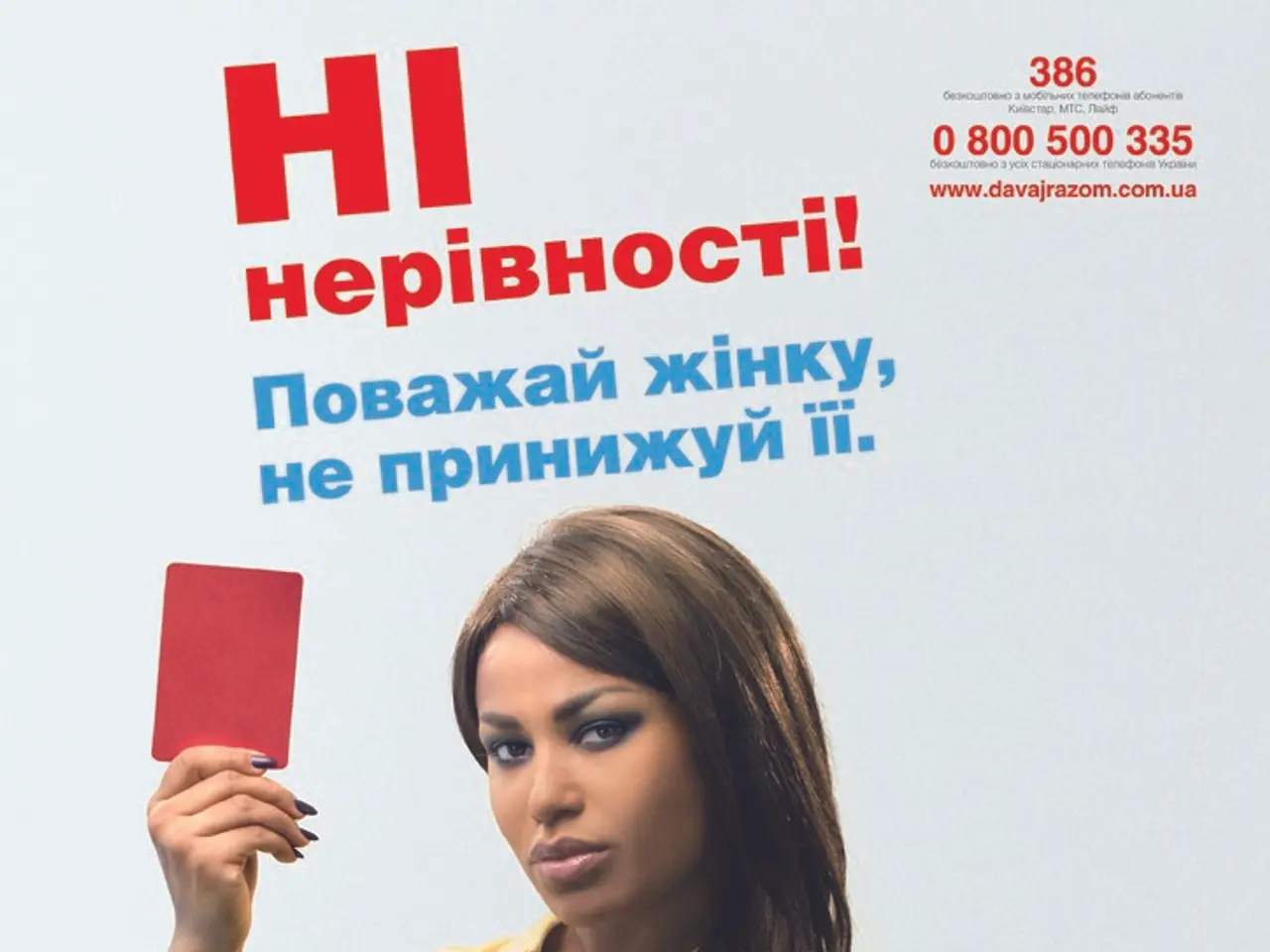 In this image a lady wearing yellow t-shirt is standing. She is holding a red card. On the top...