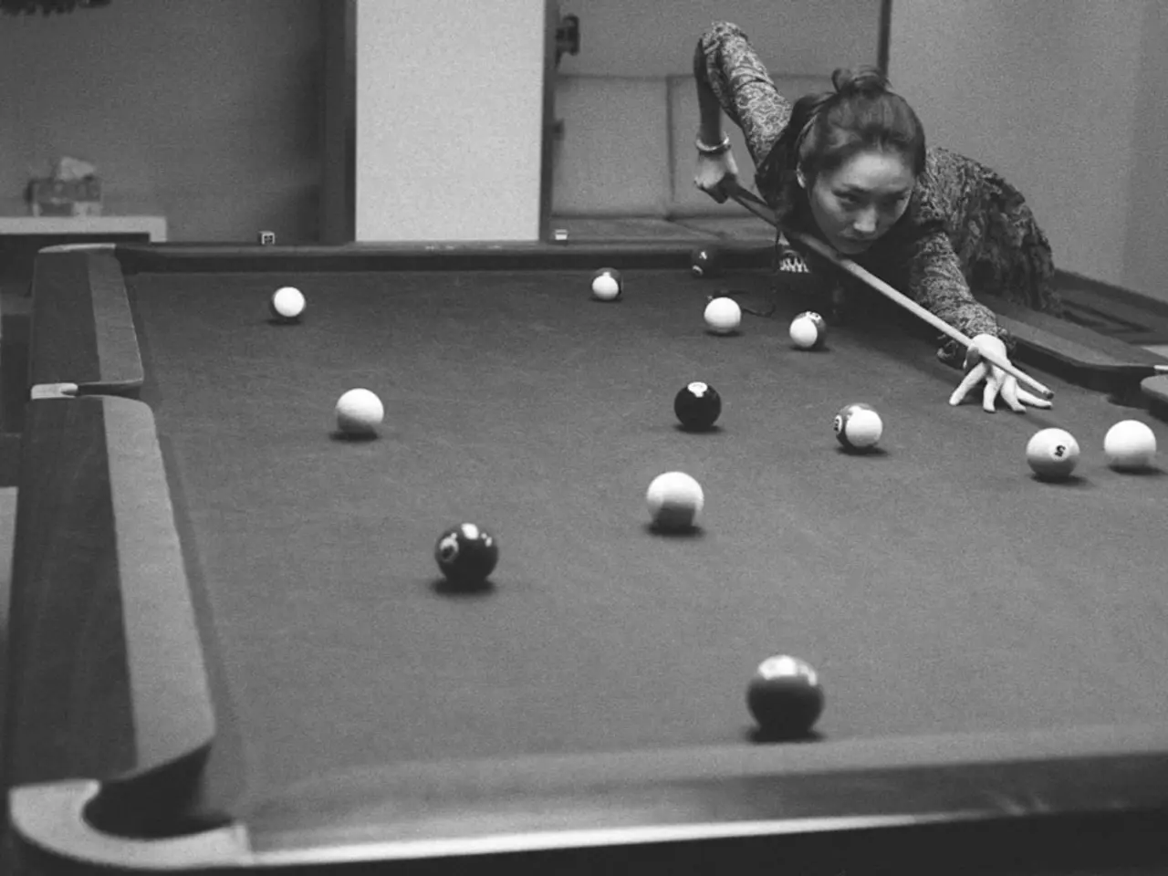 There is a snooker table in this picture on which some balls were there. A woman is playing with...