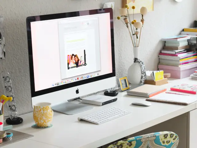 In the foreground of this image, on the desk, there are tapes, a mug with markers and pens, a cup,...